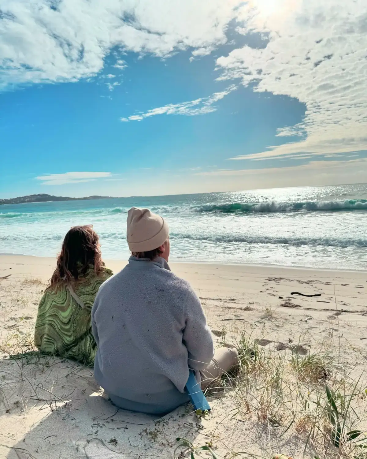 Couple sitting on Praia de Carnota looking out at the Atlantic